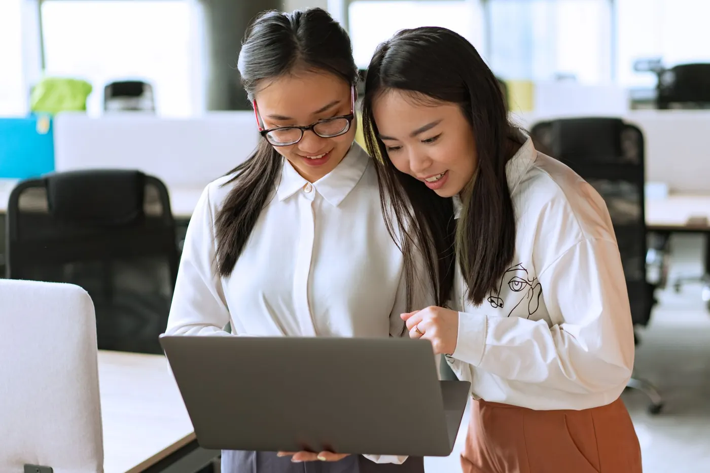 Two colleagues learning something new on a laptop together